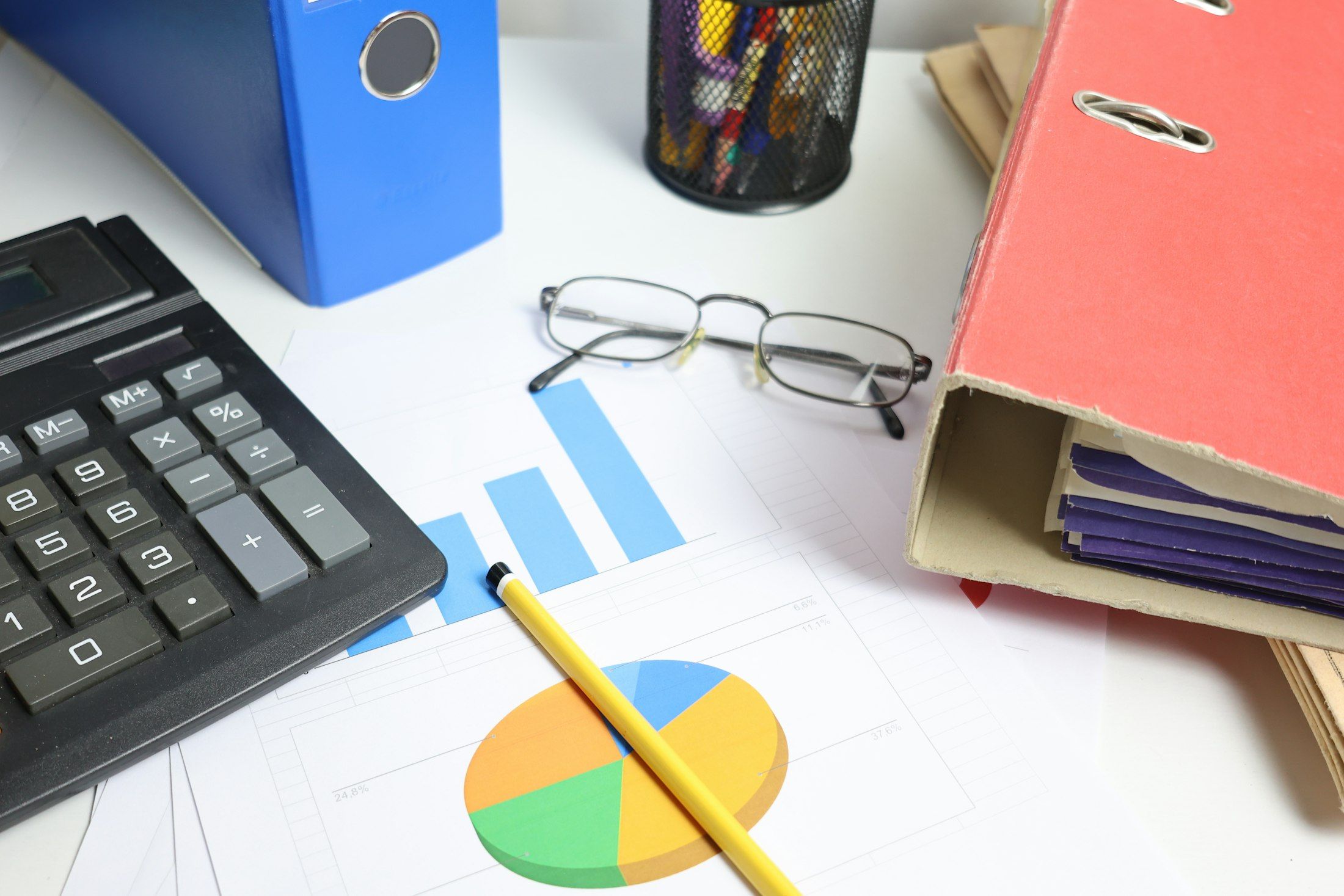 Calculator, ring binders and charts on a bookkeeper's desk, bookkeeping services Monetaire Accountants Worthing