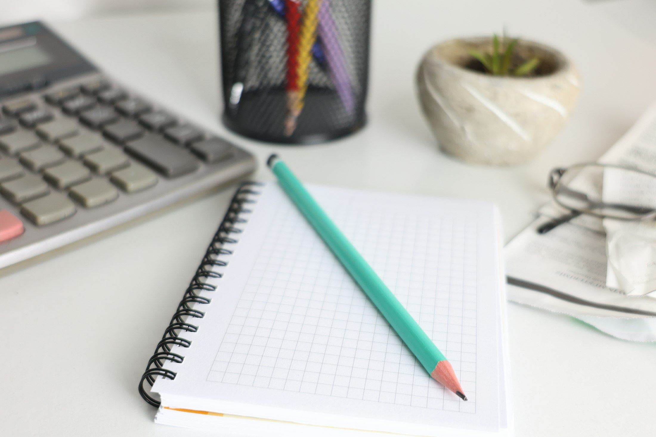 Desk with notebook, pencil and calculator at Monetaire Accountants in Worthing